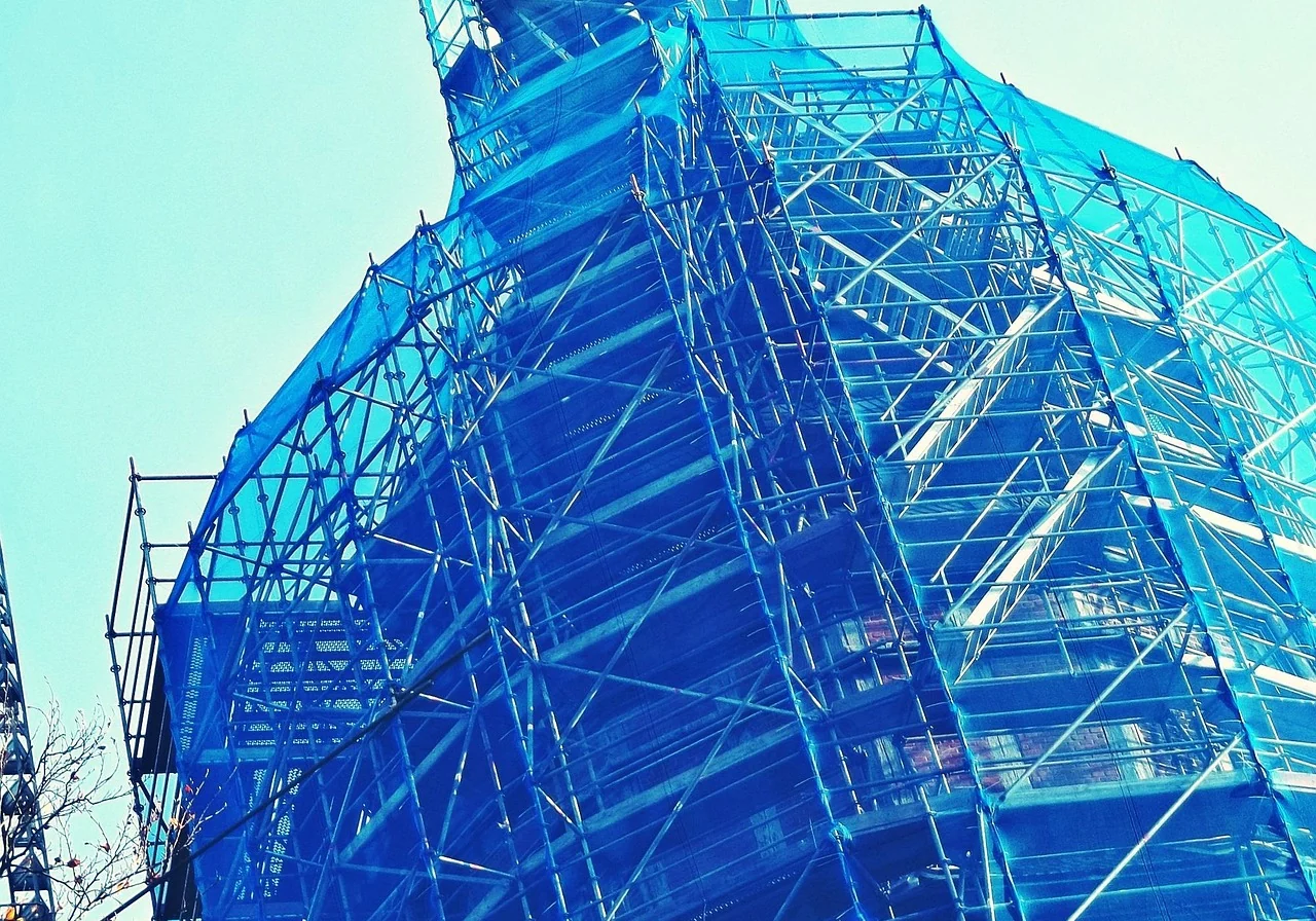 外壁塗装のために足場とネットを設置した建物